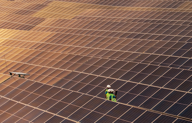 Aerial view of a solar farm with a technician at Bhimsar, Rajasthan