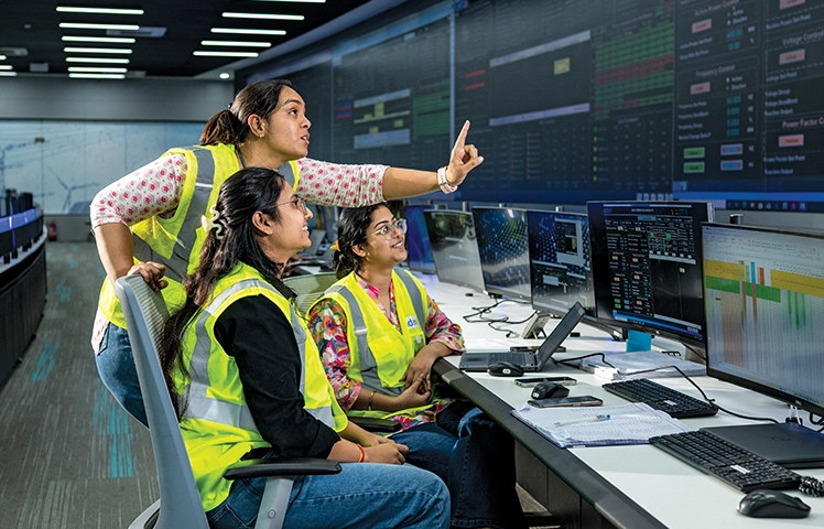 Women professionals in AGEL control room (hi-vis vests)
